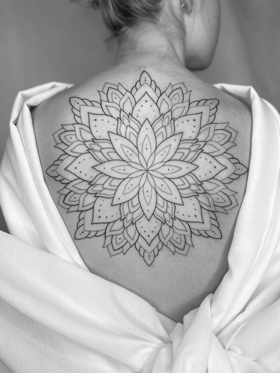 Lotus mandala fine line tattoo on upper back by Caroline Lindskov