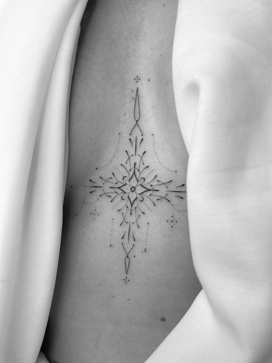Delicate ornamental fine line tattoo on ribs by Caroline Lindskov