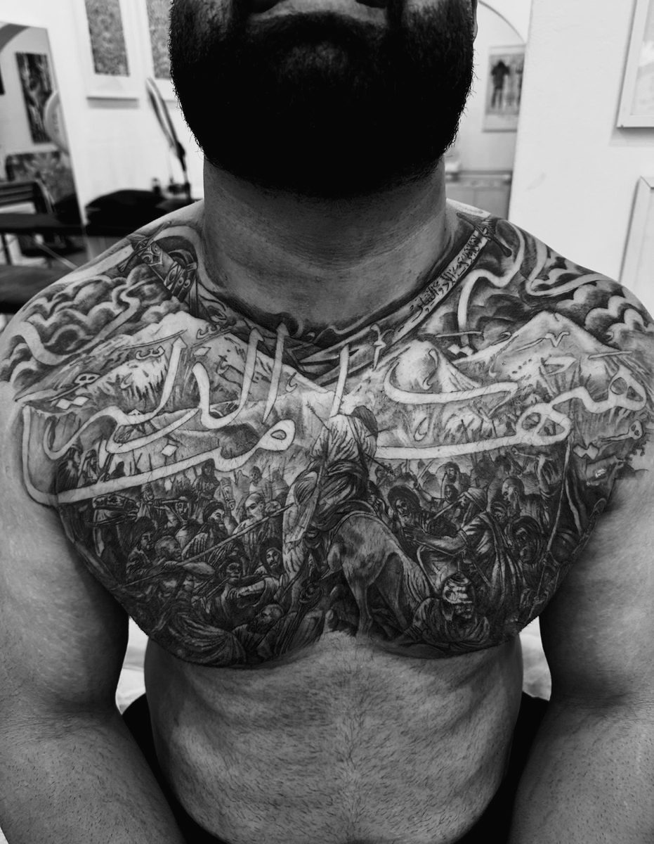 Persian battle scene chest tattoo in black and grey realism by Charlie Lund