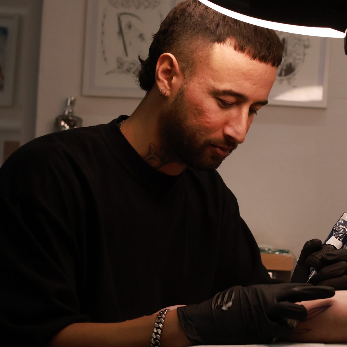 Konrad Tomimura tattooing a client at Prana Tattoo studio